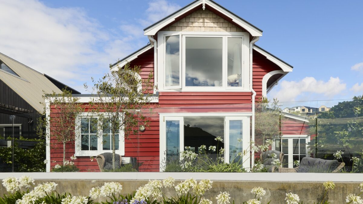 Waterfront view of The Red Cottage with French doors open to the deck