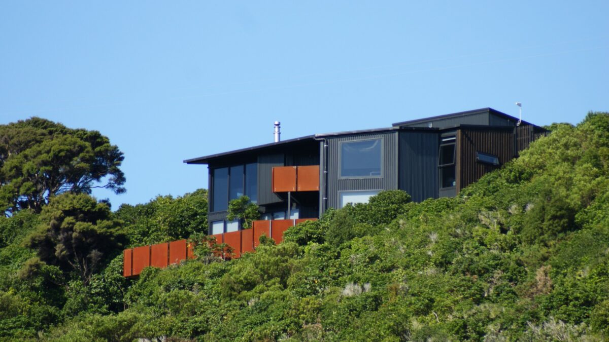 Front view of Tata Beach House perched on bush-clad hillside overlooking Golden Bay in the Tasman region