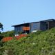 Front view of Tata Beach House perched on bush-clad hillside overlooking Golden Bay in the Tasman region