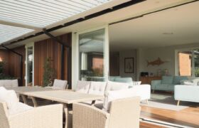 Outdoor dining setting beneath adjustable louvre roof at Tai Tapu alterations project