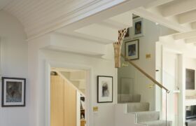Living area looking toward the stair, where the lightwell and pendant bring soft daylight into the centre of the home.