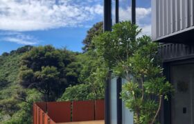 Front decks and bush landscape framing panoramic views of Golden Bay