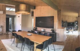 Interior living area showing exposed cross-laminated timber structure and natural light in Tata Beach House