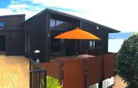 Black Colorsteel and cedar board exterior of modern Tata Beach home in Golden Bay
