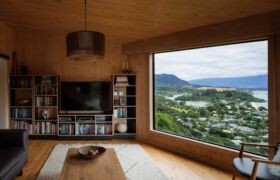 Living room with a large picture window looking across Tata Beach and Golden Bay.